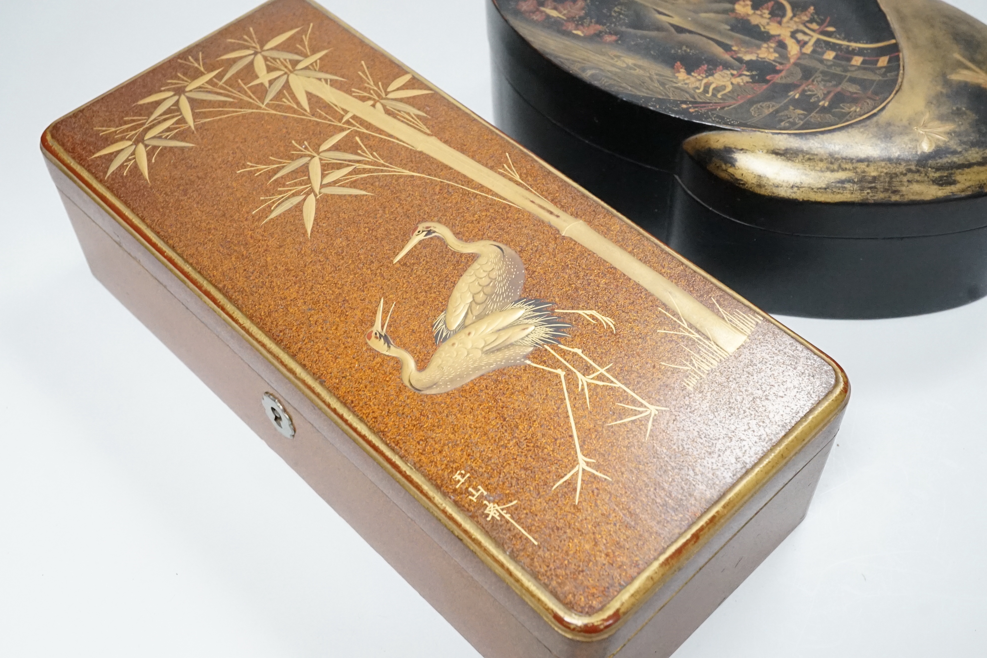 A Japanese lacquer rectangular box and cover, signed, Taisho period and a Japanese clam-shell shaped lacquer box and cover, Meiji period, largest 26cm wide (2)